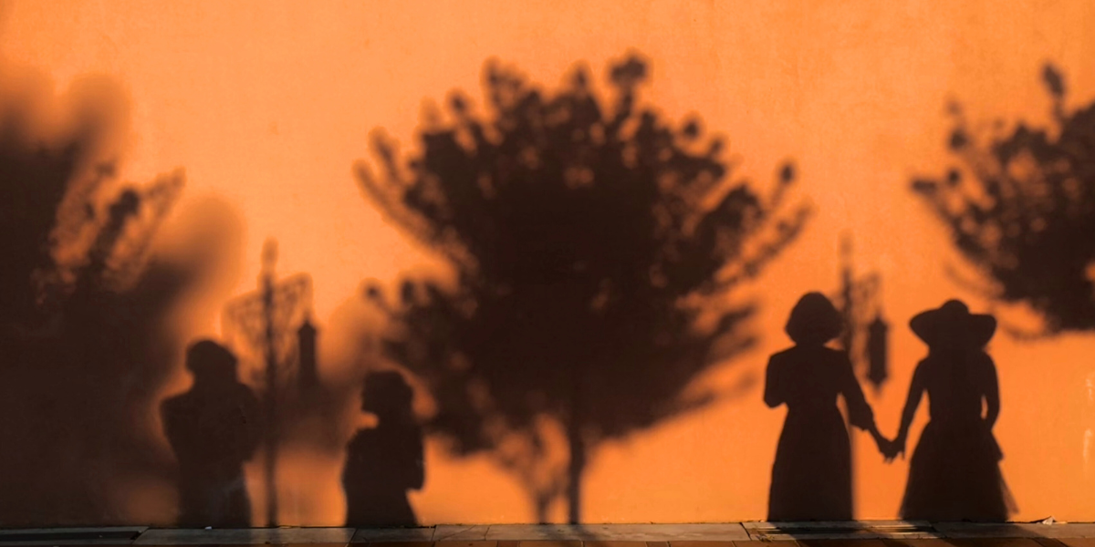 ombre di persone e alberi su sfondo arancione